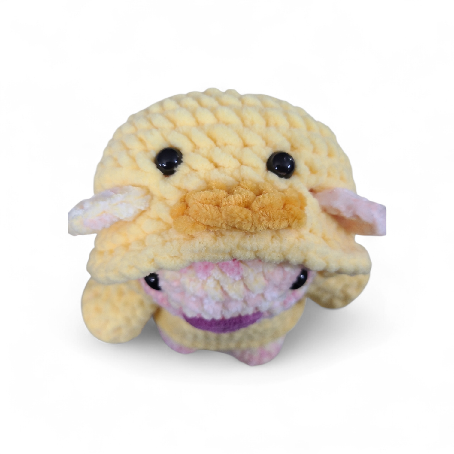Crocheted yellow duck hoodie on a pink and yellow bear on a white background