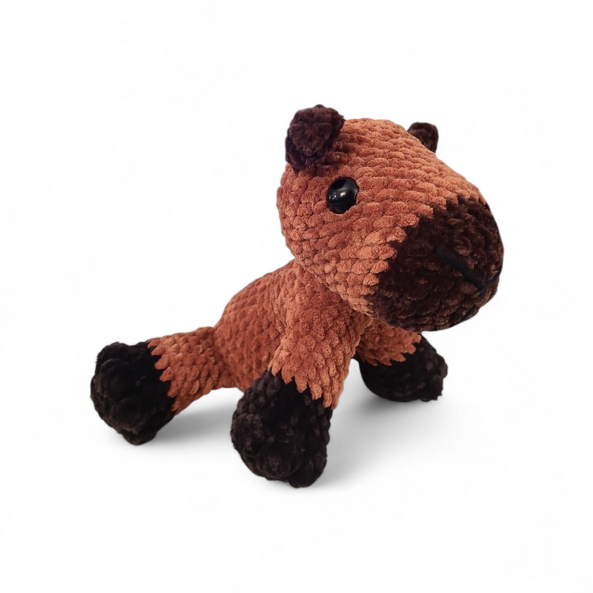 Crocheted capybara with a brown body and dark brown snout on a white background