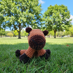Crocheted capybara with a brown body and dark brown snout on a white background