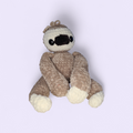 Crochet Sloth with tan body and cream face on a lilac background