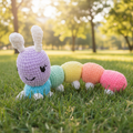Colorful caterpillar-shaped crocheted plush on a beige background