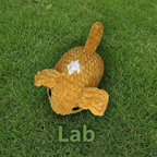 Crocheted brown dog with a white diamond shape on its back on a white background
