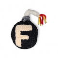 Crocheted plushie resembling a black bomb with a letter 'F' and colorful tail on a white background